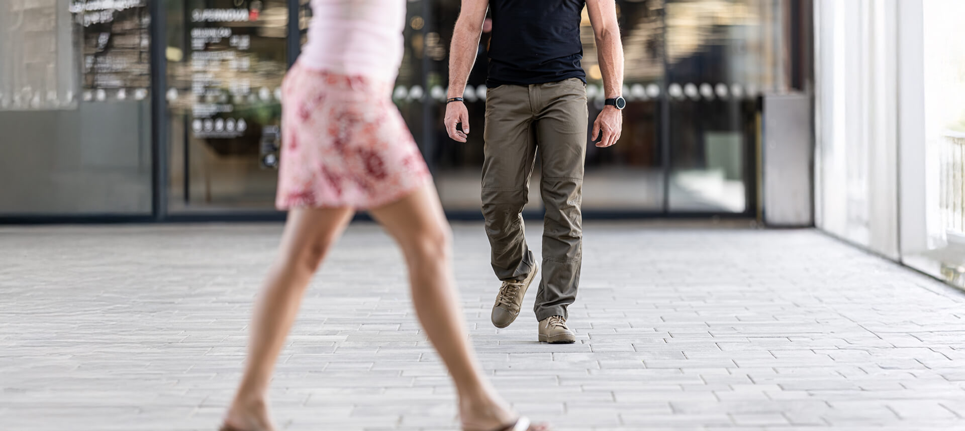 Individual walking confidently in an urban setting while observing his environment, demonstrating situational awareness.